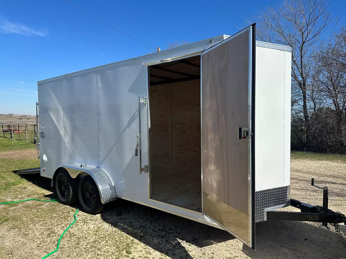 A 16ft white enclosed cargo trailer with rear doors open showing interior
