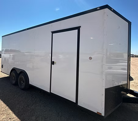 A 20ft white enclosed cargo trailer with side door on dirt ground